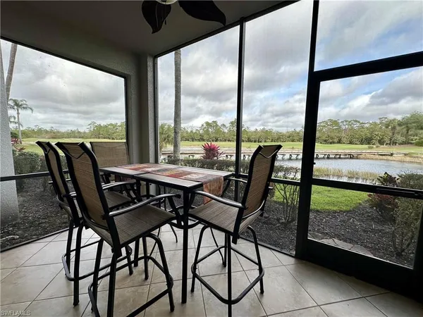 a view of a city from a dining room with furniture and floor to ceiling window
