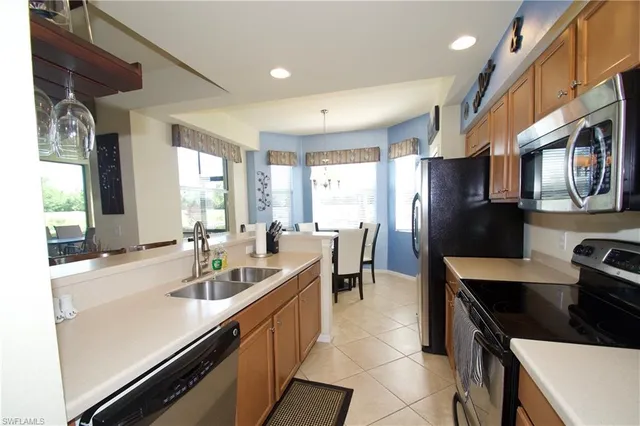 a kitchen with stainless steel appliances granite countertop a sink a stove and a refrigerator