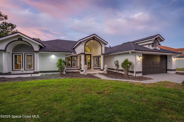 a front view of a house with patio and garden