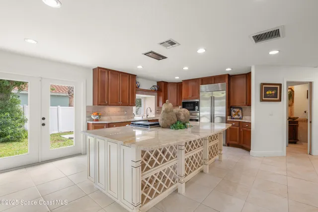 a kitchen with stainless steel appliances granite countertop a refrigerator and a sink