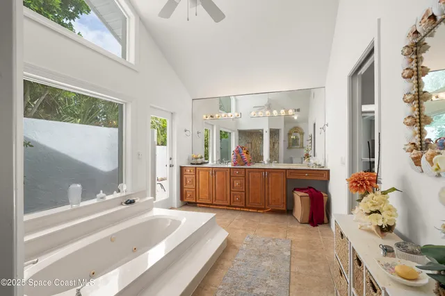 a spacious bathroom with a tub sink and mirror