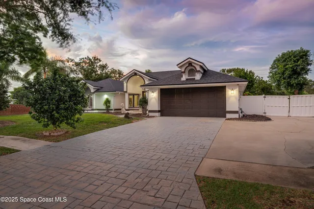 a front view of a house with a garden and mountain view