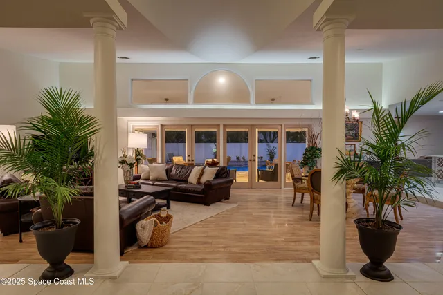 a living room with furniture and potted plants