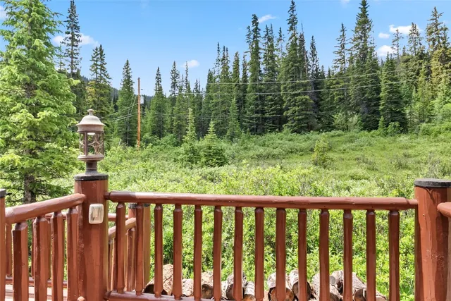 a view of a forest filled with trees and buildings in the background
