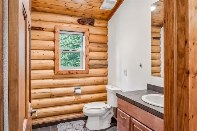 a bathroom with a toilet a sink and a shower curtain