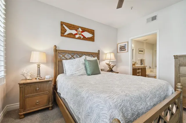 a bedroom with a bed and a lamp on dresser