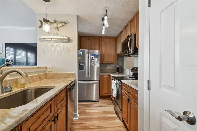 a kitchen with stainless steel appliances granite countertop a sink and a refrigerator