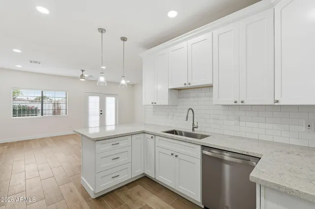 a kitchen with white cabinets and window