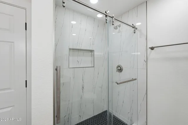 a bathroom with a shower and a glass door