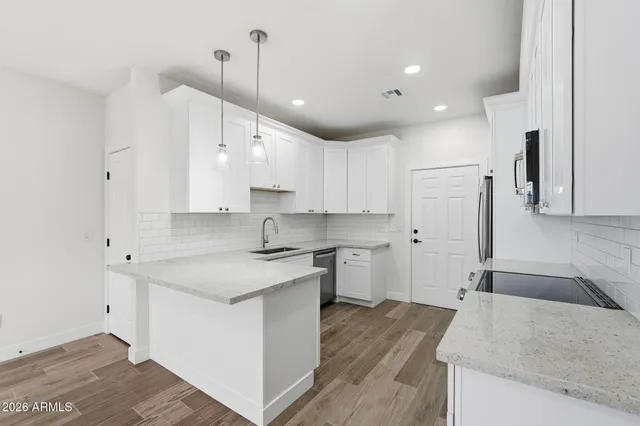 a large kitchen with stainless steel appliances granite countertop a sink a stove and a refrigerator