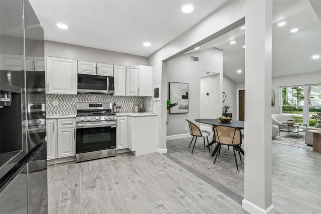 a kitchen with microwave a stove and cabinets