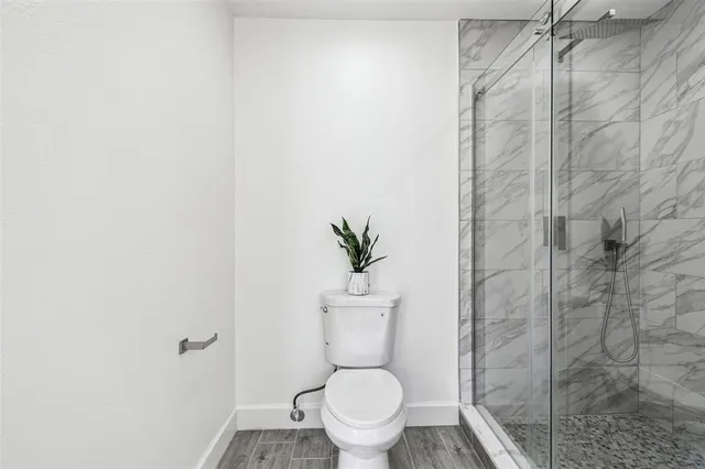 a bathroom with a toilet and a shower
