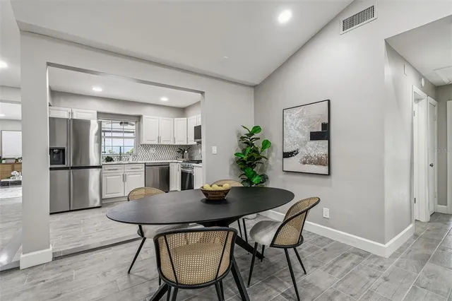 a kitchen with a dining table chairs refrigerator and cabinets