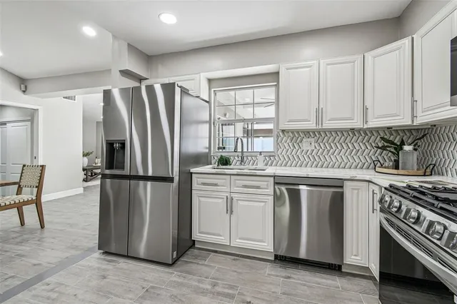 a kitchen with a refrigerator sink stove and cabinets