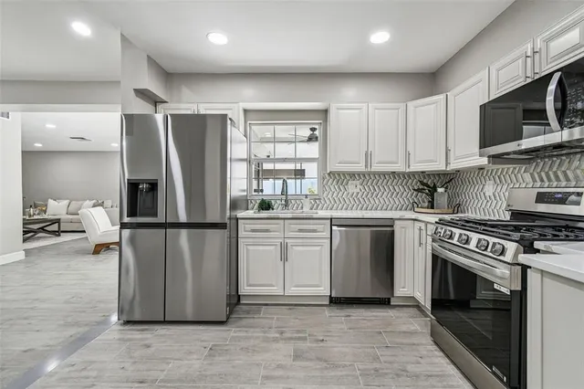 a kitchen with a refrigerator and a stove top oven