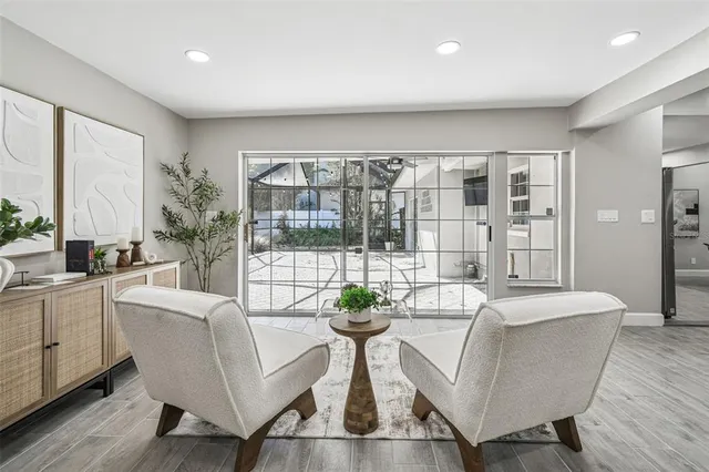 a living room with furniture a potted plant and a large window