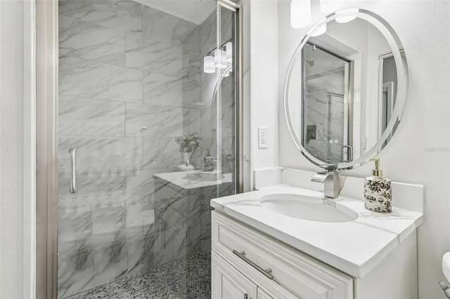 a bathroom with a sink vanity granite and a mirror