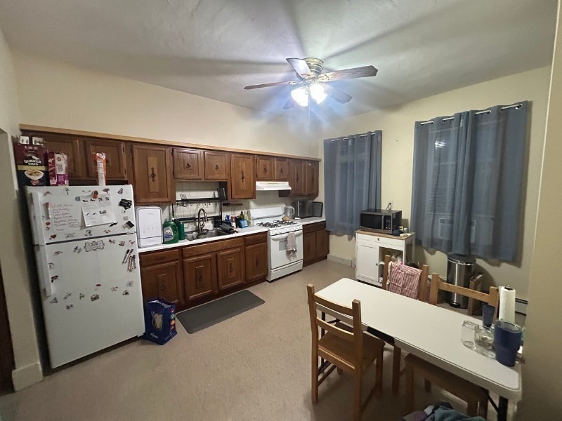 a kitchen with a refrigerator a stove a sink dishwasher and white cabinets with wooden floor