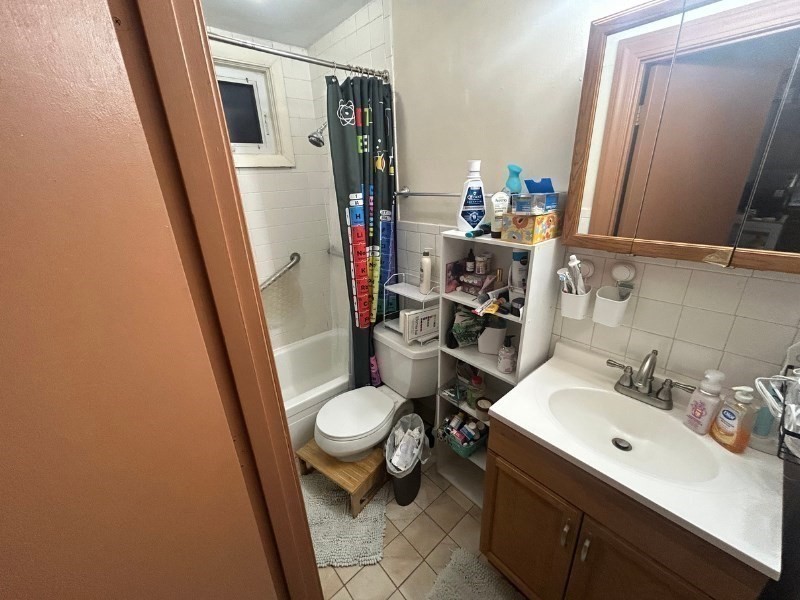 122 A Spring Street, Unit 3 Cambridge, MA 02141 - Photo 11 of 11 a bathroom with sink a mirror a toilet and a shower