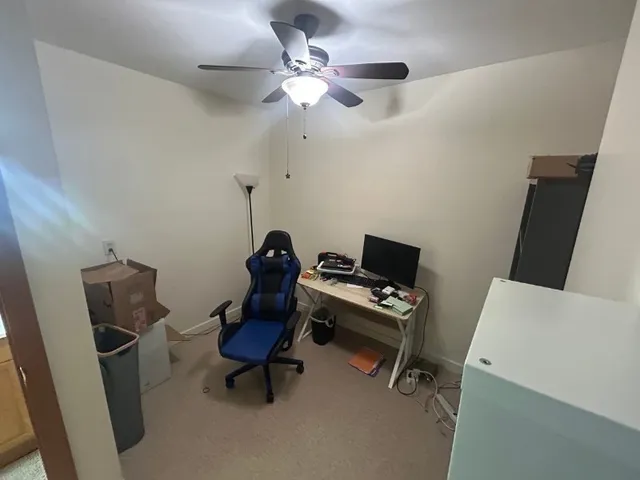 a view of a workspace with furniture and a window