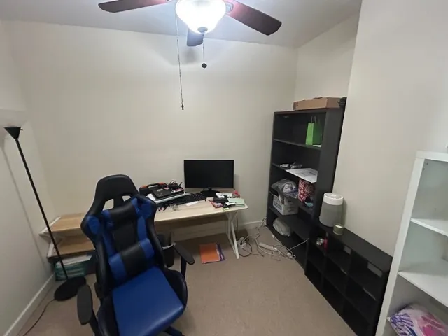 a view of a workspace with furniture and a window