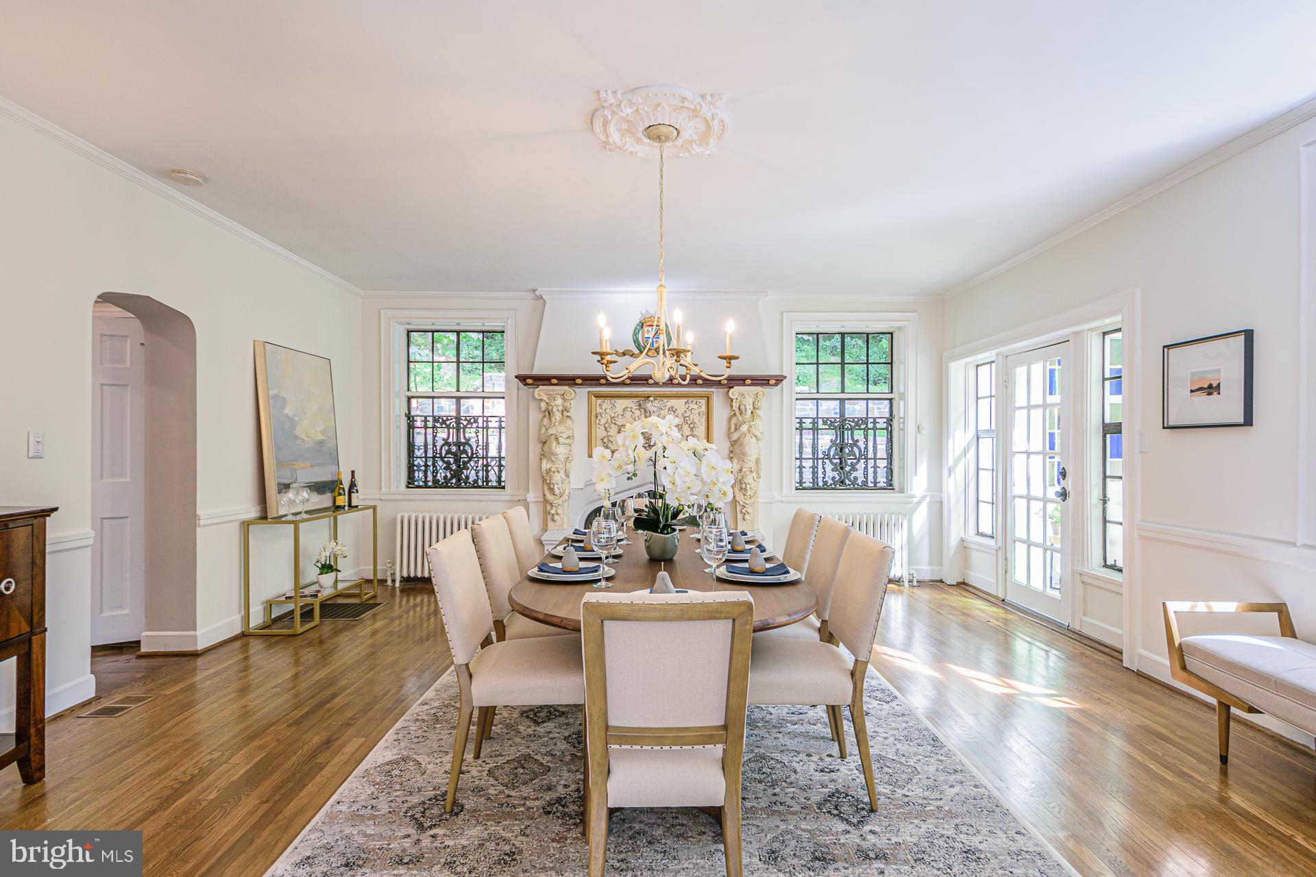 4331 Blagden Avenue Northwest Washington, DC 20011 - Photo 14 of 38 a dining room with wooden floor a chandelier a glass table and chairs