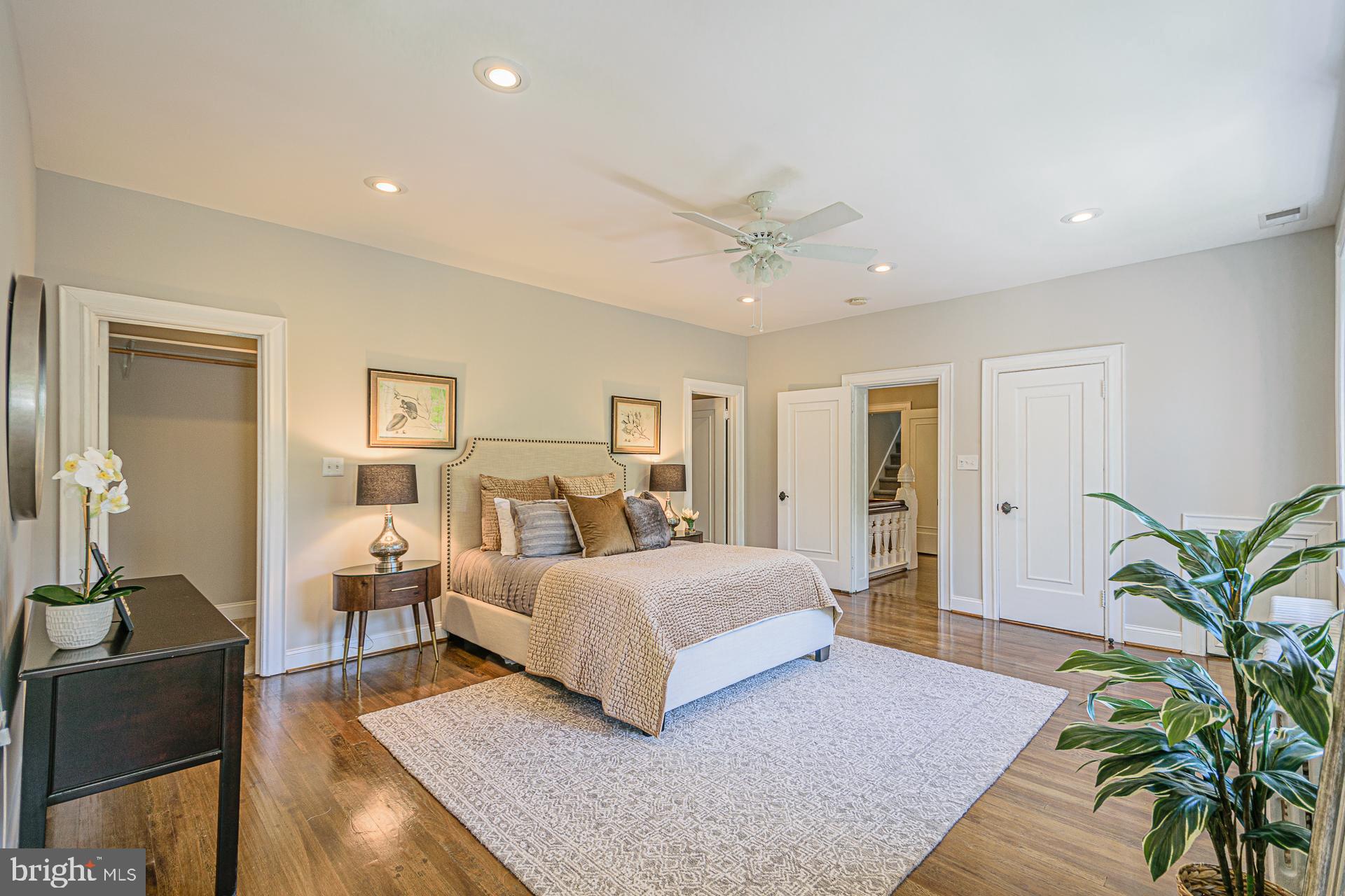 4331 Blagden Avenue Northwest Washington, DC 20011 - Photo 19 of 38 a spacious bedroom with a large bed and a chandelier