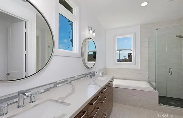 a bathroom with a granite countertop double vanity sink and mirror