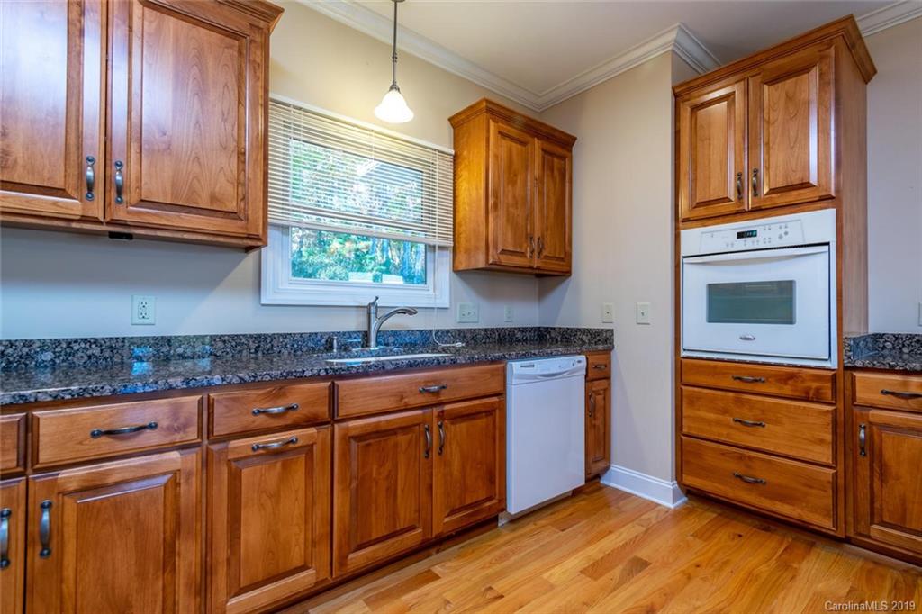 170 Towhee Trail Tryon, NC 28782 - Photo 14 of 38 a kitchen with stainless steel appliances granite countertop wooden cabinets a sink and dishwasher with wooden floor