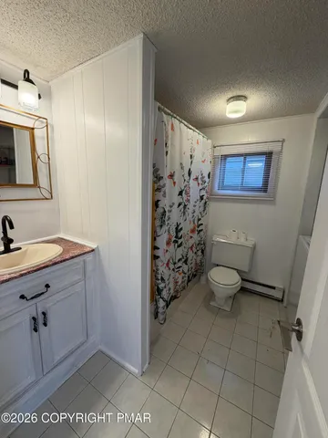 a bathroom with a granite countertop sink a toilet and a shower