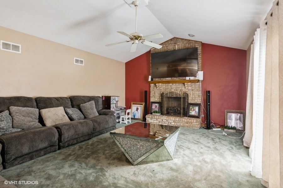 19265 Lange Street Lansing, IL 60438 - Photo 7 of 18 a living room with furniture a fireplace and a flat screen tv