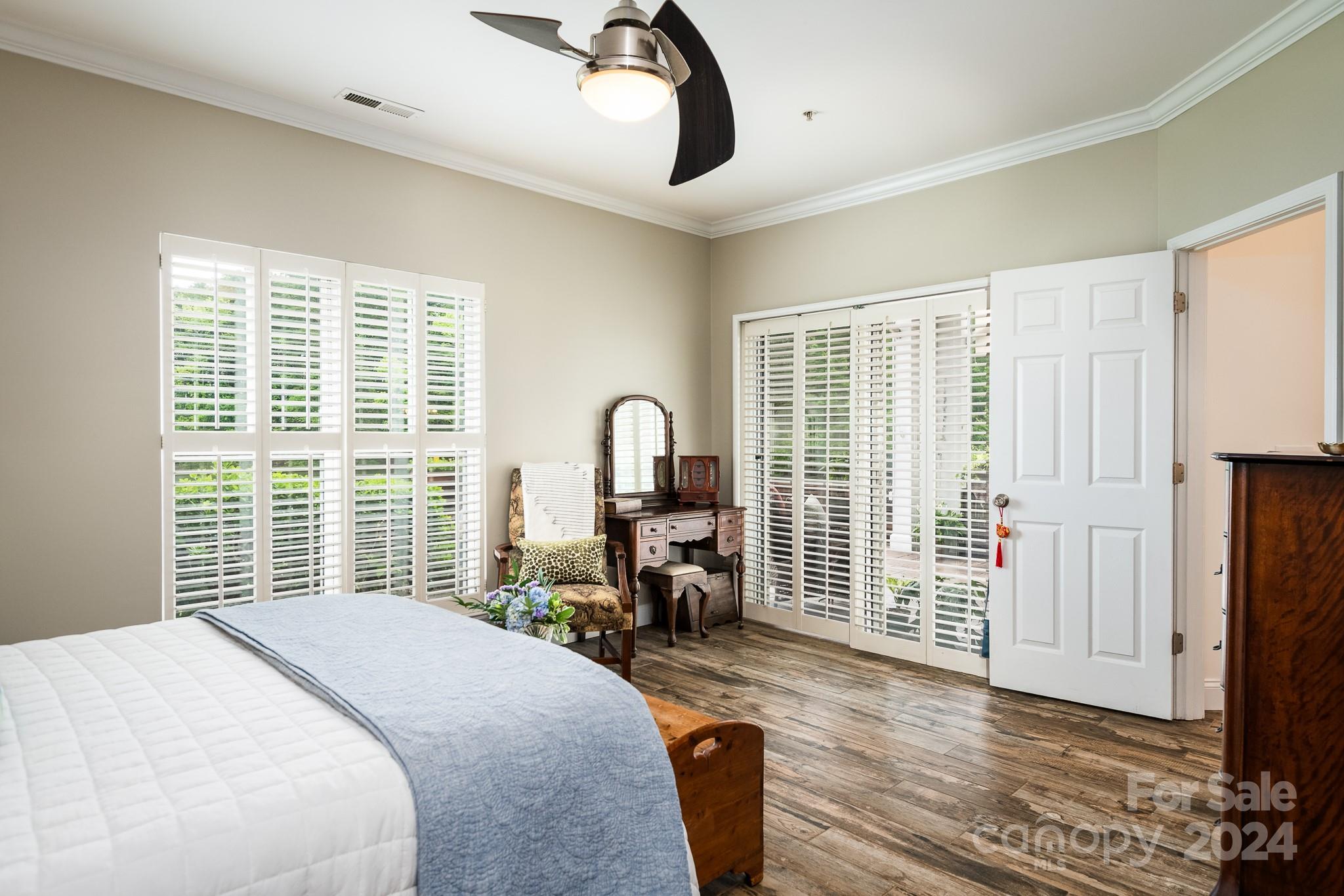 860 Jetton Street, Unit 64 Davidson, NC 28036 - Photo 17 of 33 a bedroom with a bed large windows and wooden floor