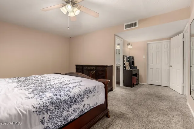 a spacious bedroom with a bed and a chandelier