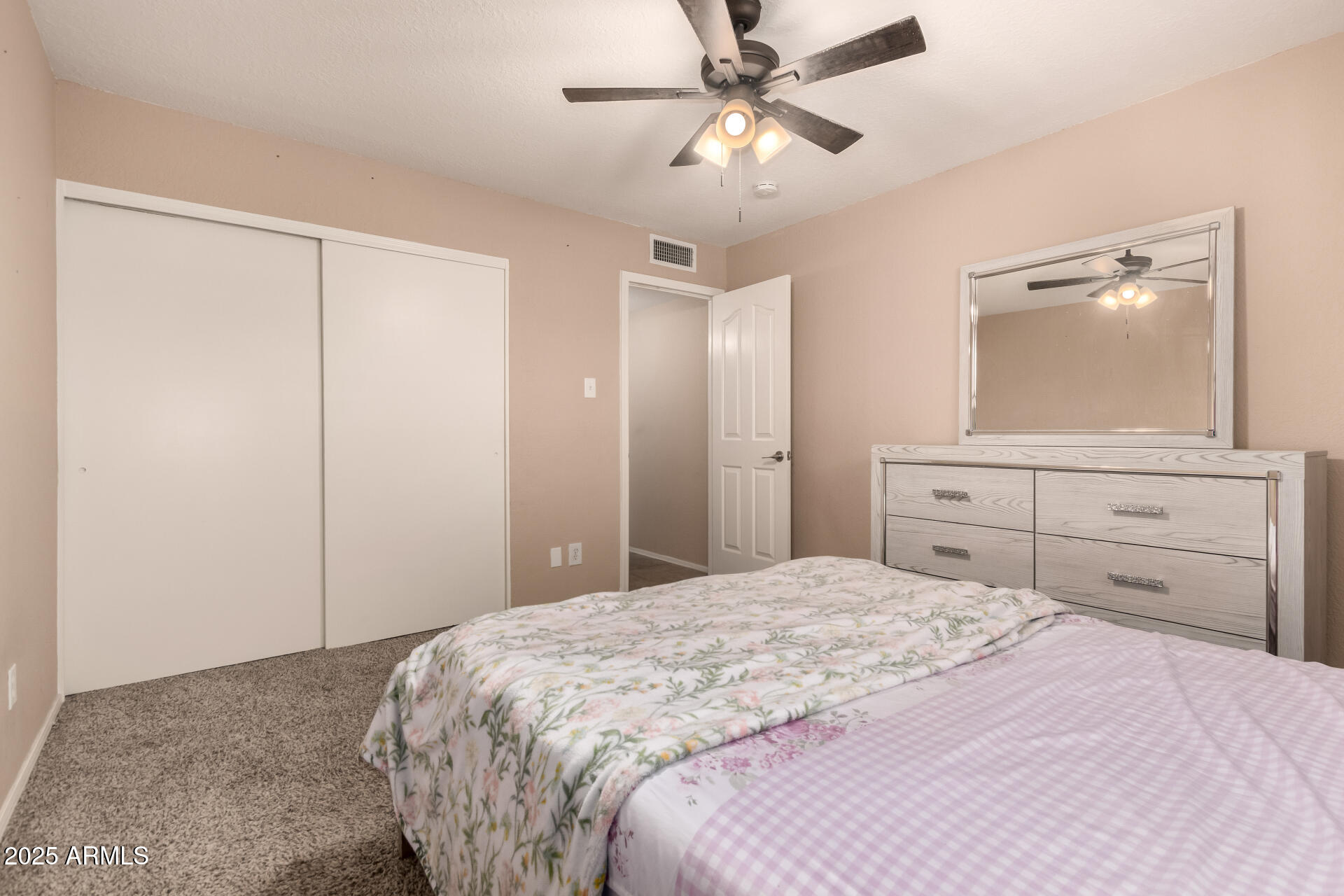 3529 West St Moritz Lane Phoenix, AZ 85053 - Photo 24 of 34 a bedroom with a large bed and a mirror on dresser