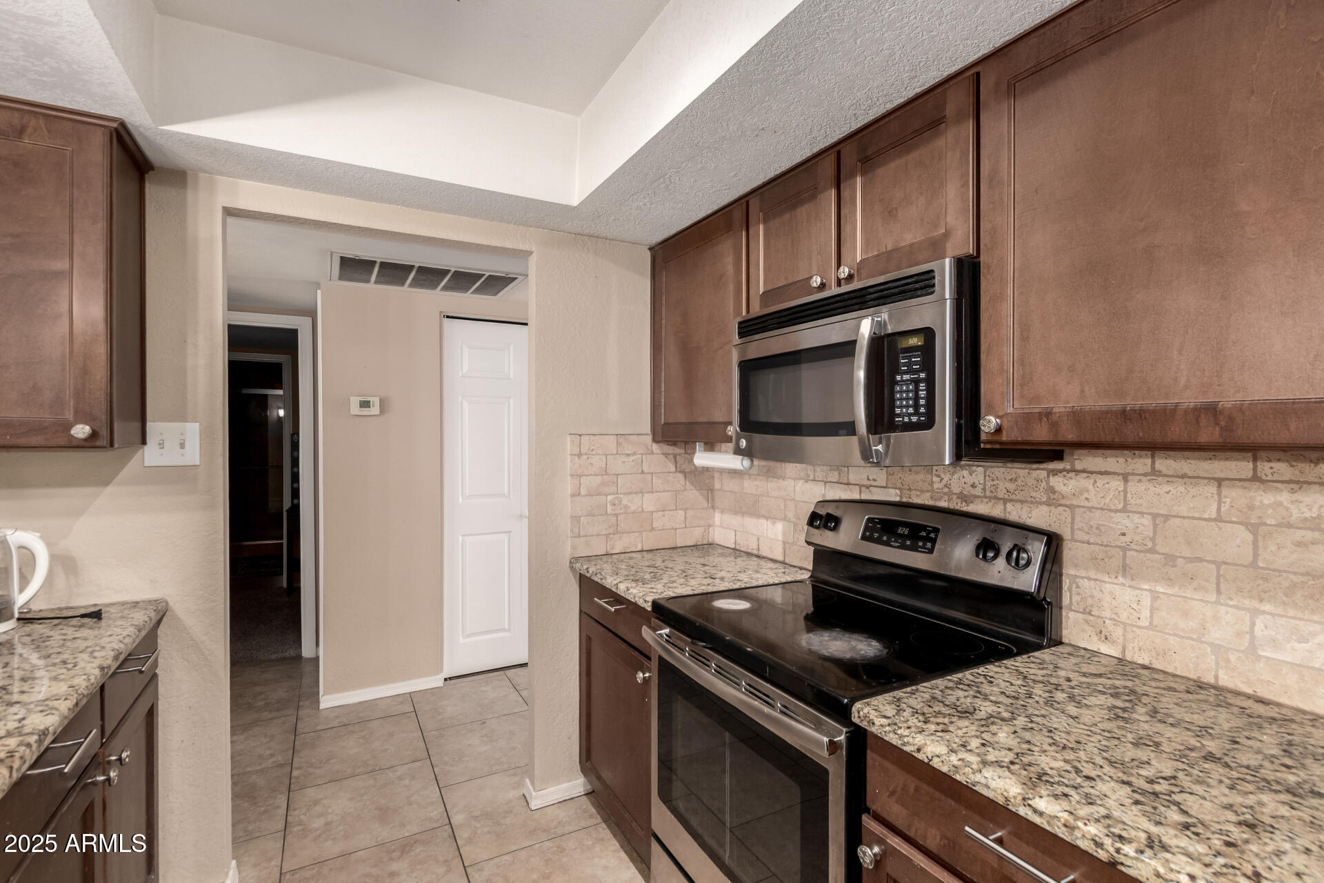 3529 West St Moritz Lane Phoenix, AZ 85053 - Photo 6 of 34 a kitchen with granite countertop a stove and a microwave