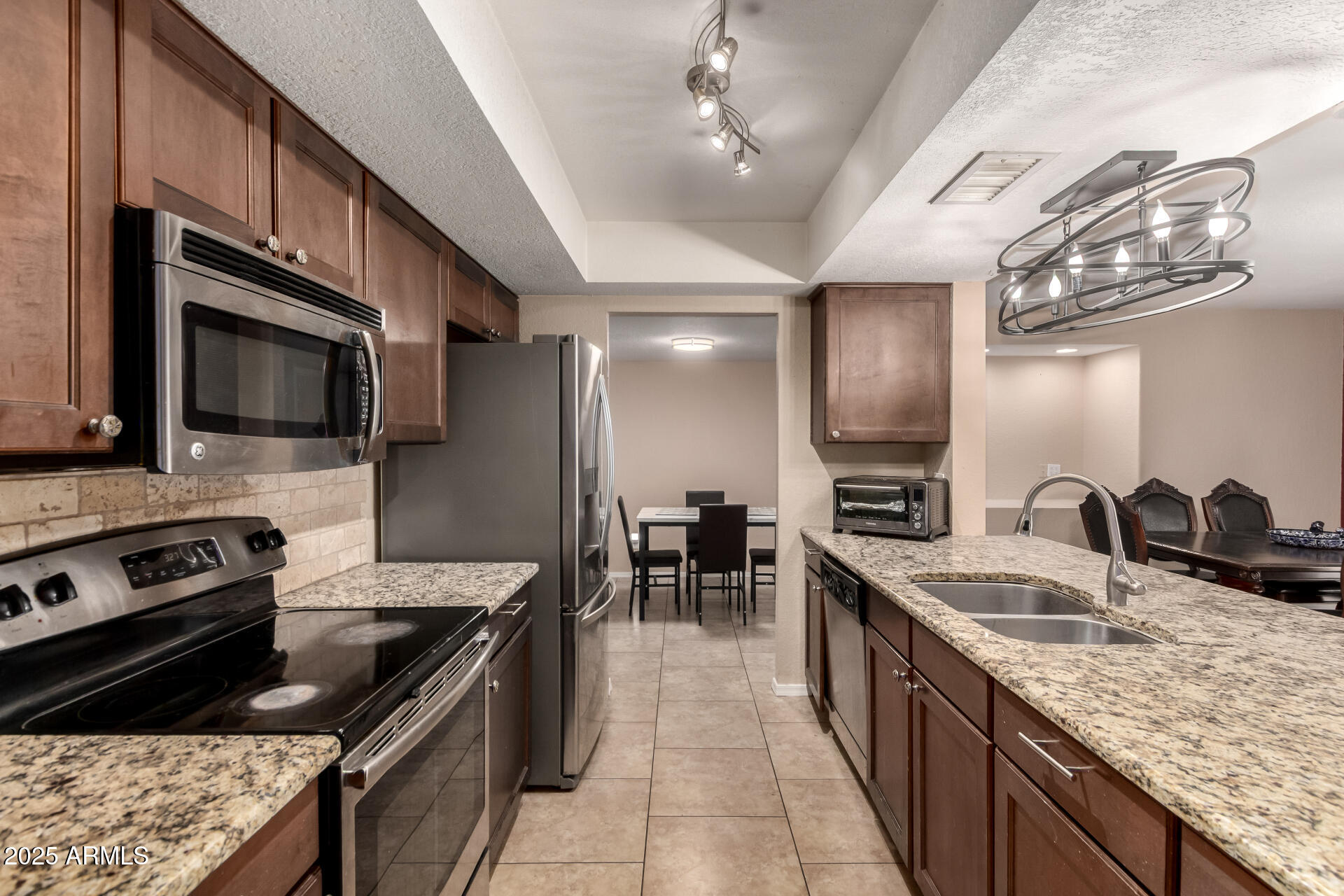 3529 West St Moritz Lane Phoenix, AZ 85053 - Photo 7 of 34 a kitchen with stainless steel appliances granite countertop a sink stove and refrigerator