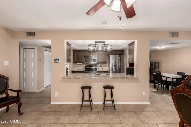a kitchen with stainless steel appliances kitchen island granite countertop a table and chairs in it