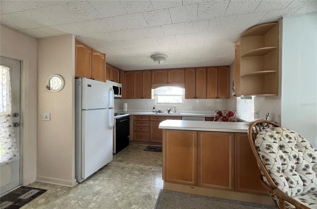1100 South Belcher Road, Unit 64 Largo, FL 33771 - Photo 15 of 52 a kitchen with cabinets a refrigerator and a sink