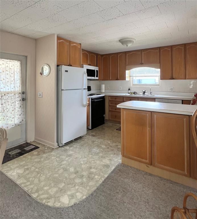 1100 South Belcher Road, Unit 64 Largo, FL 33771 - Photo 16 of 52 a kitchen with a refrigerator sink and cabinets