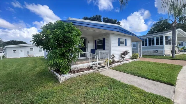 a living room with furniture a flat screen tv and kitchen view