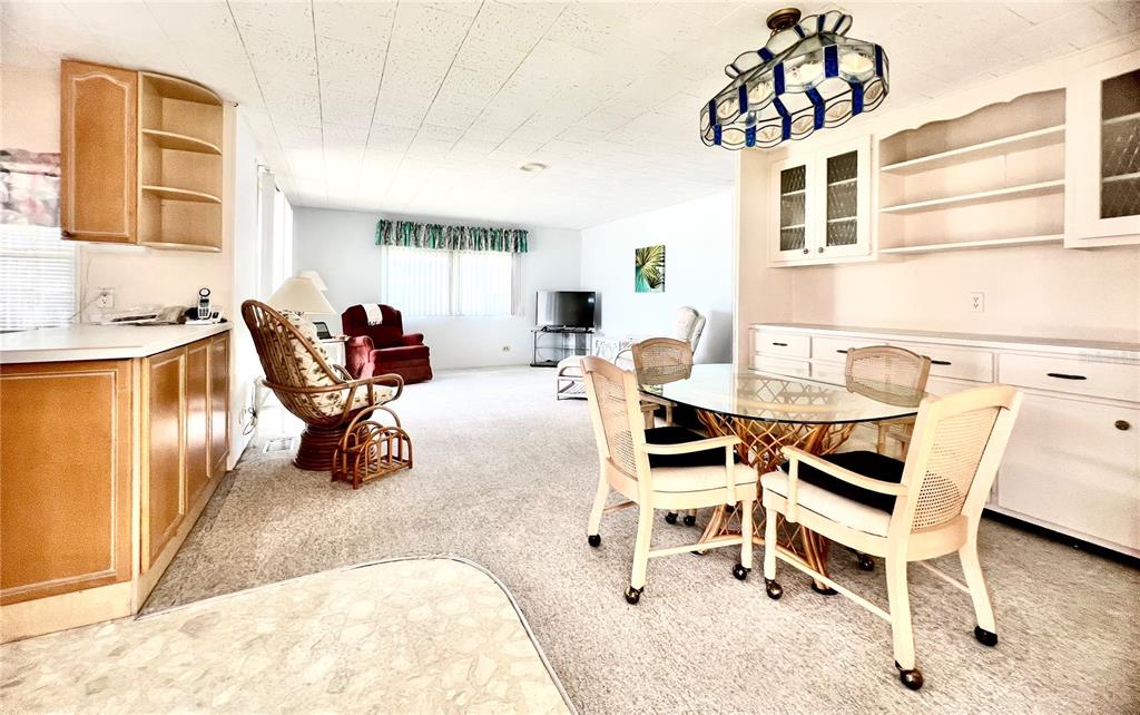 1100 South Belcher Road, Unit 64 Largo, FL 33771 - Photo 6 of 52 a living room with furniture a flat screen tv and kitchen view