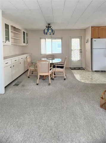 a kitchen with refrigerator cabinets dining table and chairs