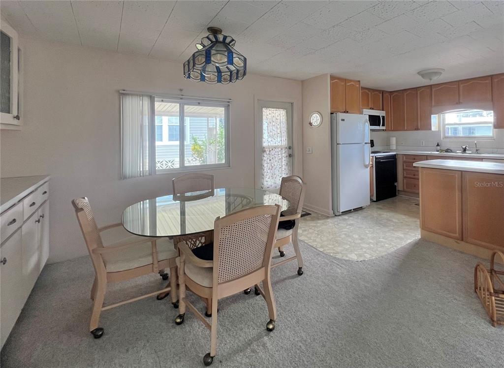 1100 South Belcher Road, Unit 64 Largo, FL 33771 - Photo 10 of 52 a kitchen with refrigerator cabinets dining table and chairs