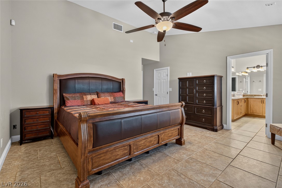 818 Manor Shores Road Henderson, NV 89002 - Photo 18 of 35 Relax in this tranquil primary bedroom featuring vaulted ceilings and direct access to a private ensuite.