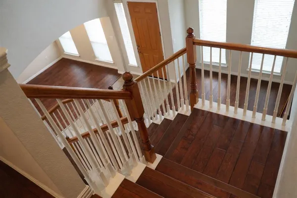 a view of staircase with railing and white walls