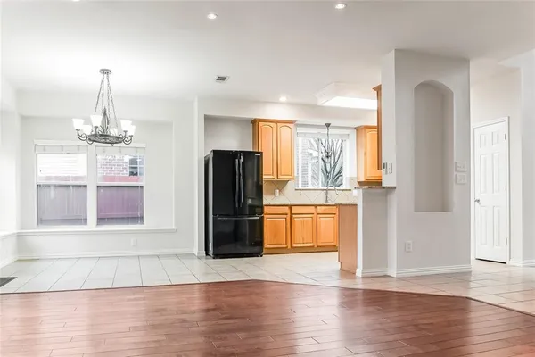a view of a kitchen with a refrigerator and wooden floor