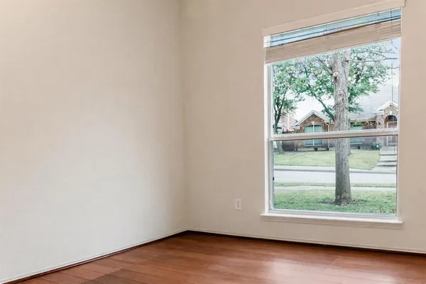 an empty room with wooden floor and a window