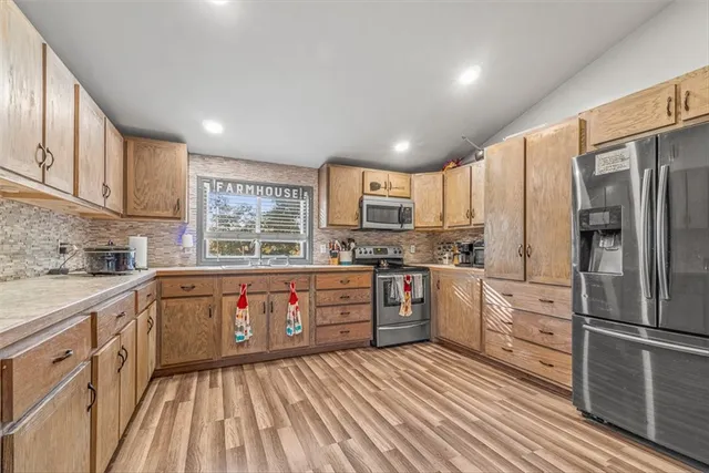 a kitchen with stainless steel appliances a refrigerator sink and cabinets
