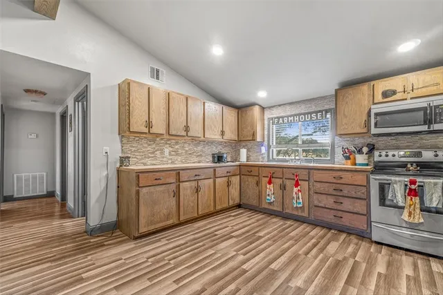 a kitchen with granite countertop a stove top oven sink and cabinets