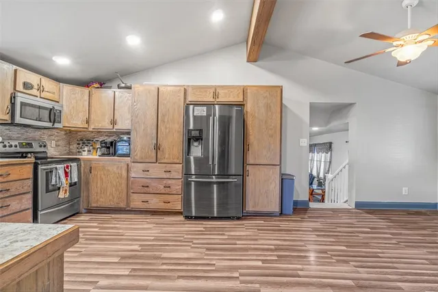 a kitchen with stainless steel appliances a refrigerator and a stove top oven
